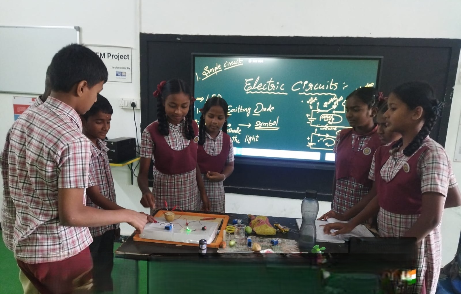 Students testing a circuit built from the science kit