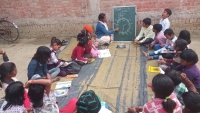 Children seated together during a Village Learning Center session