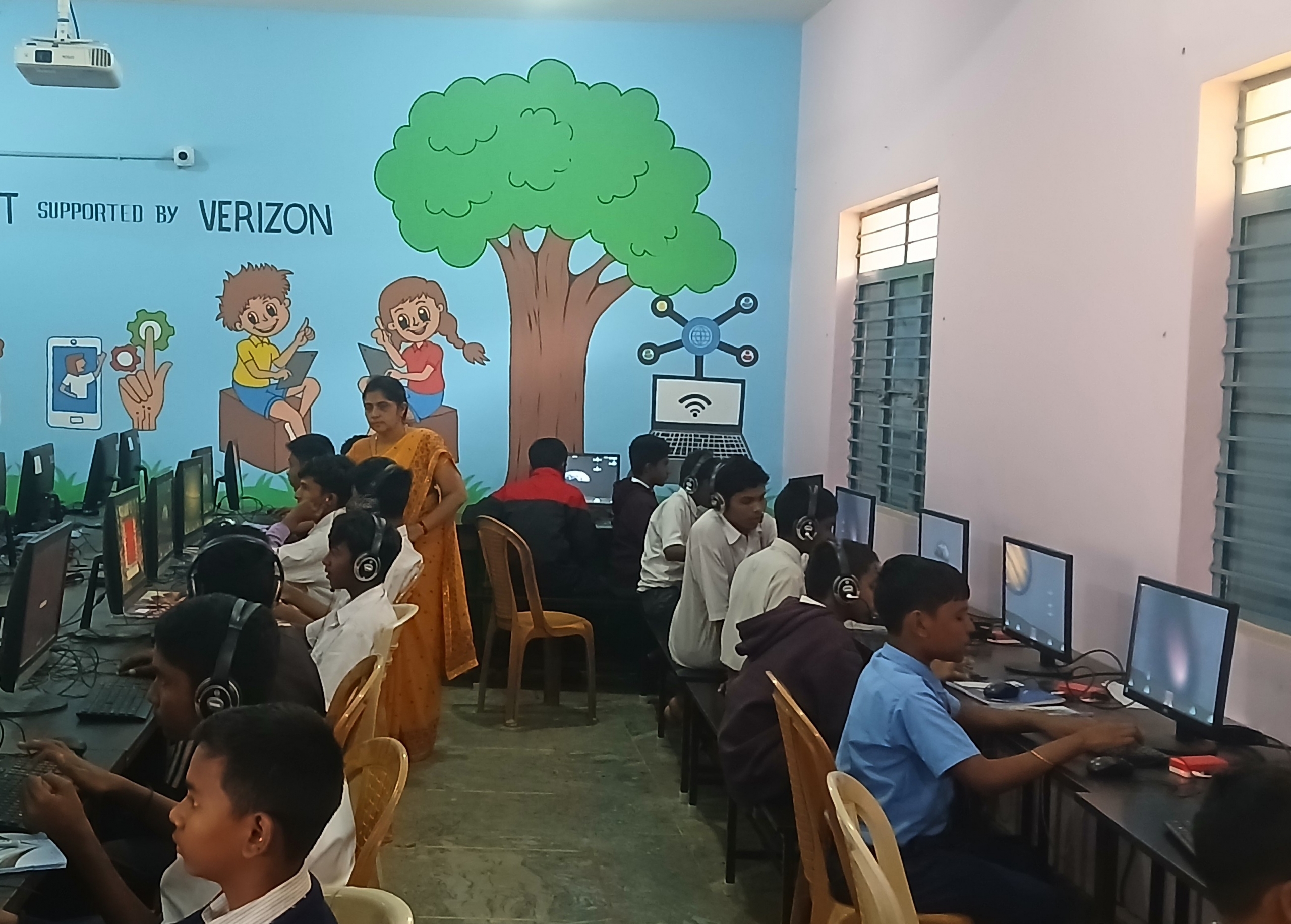 A facilitator assists students working through a self-learning module