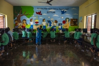 Students at computer workstations with headphones in an ICT Lab under the Karnataka Model Schools Pathways Programme, with a facilitator assisting